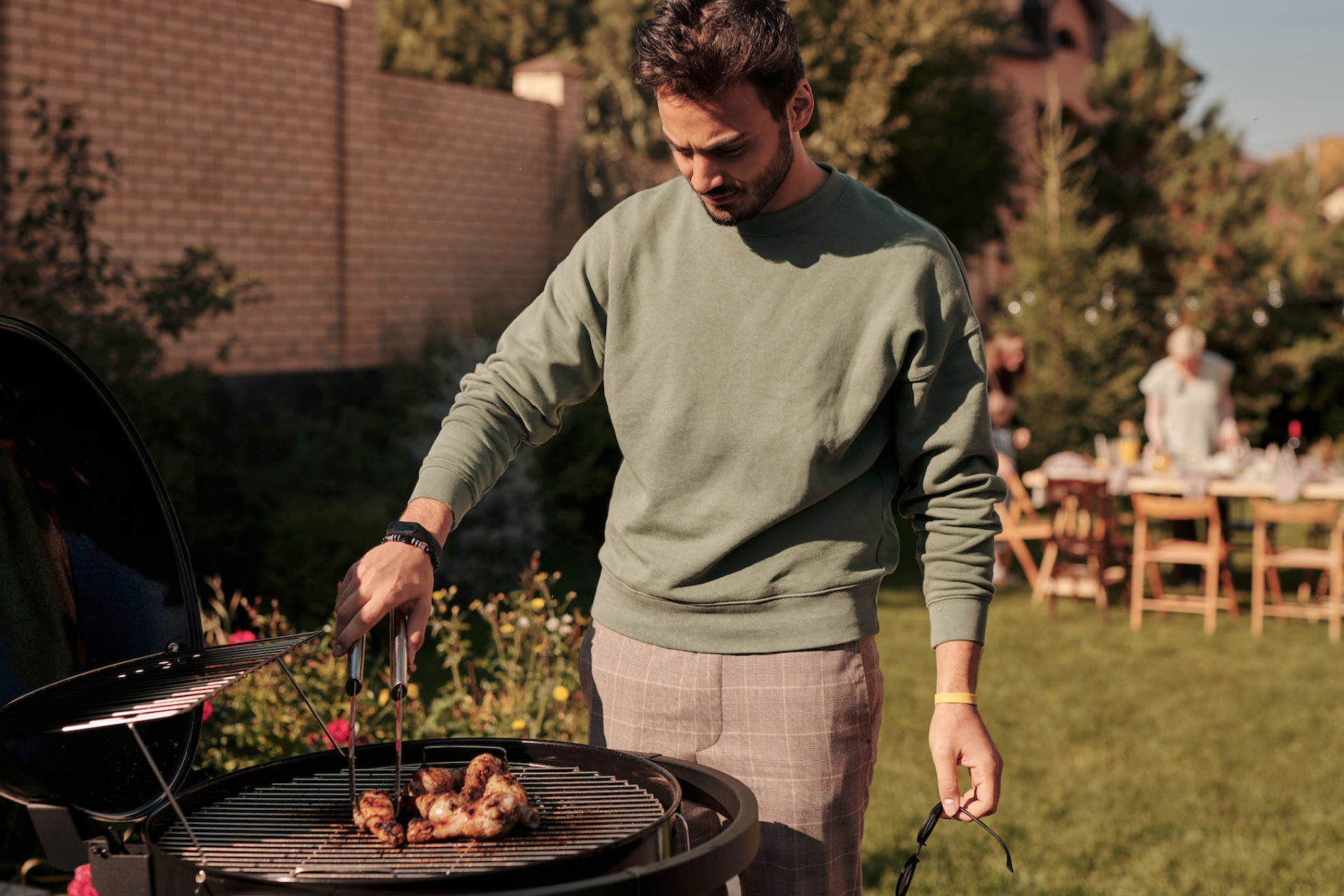 Un homme qui prépare un barbecue dans son jardin