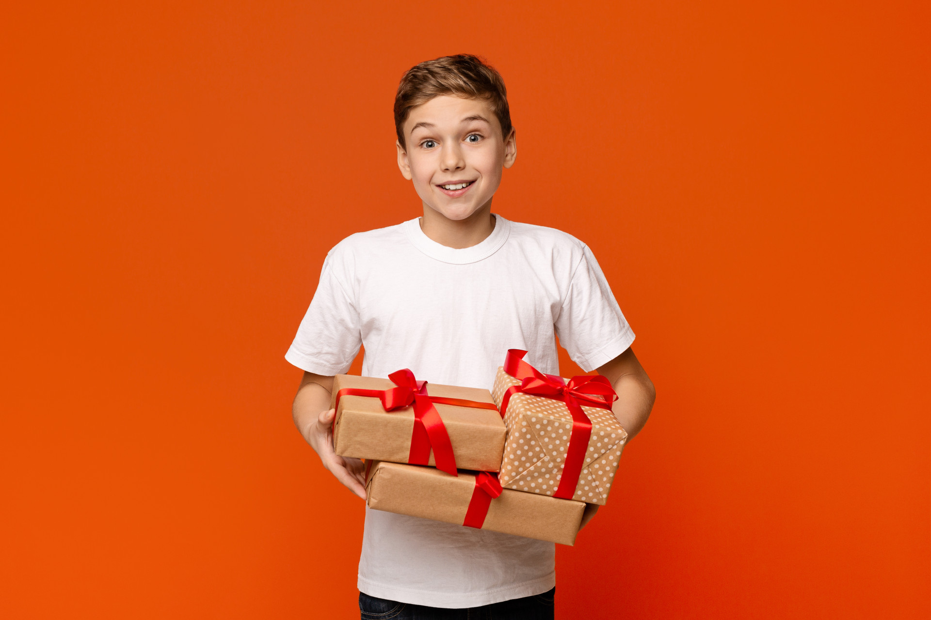 Un jeune garçon souriant s'aprête à ouvrir des cadeaux !