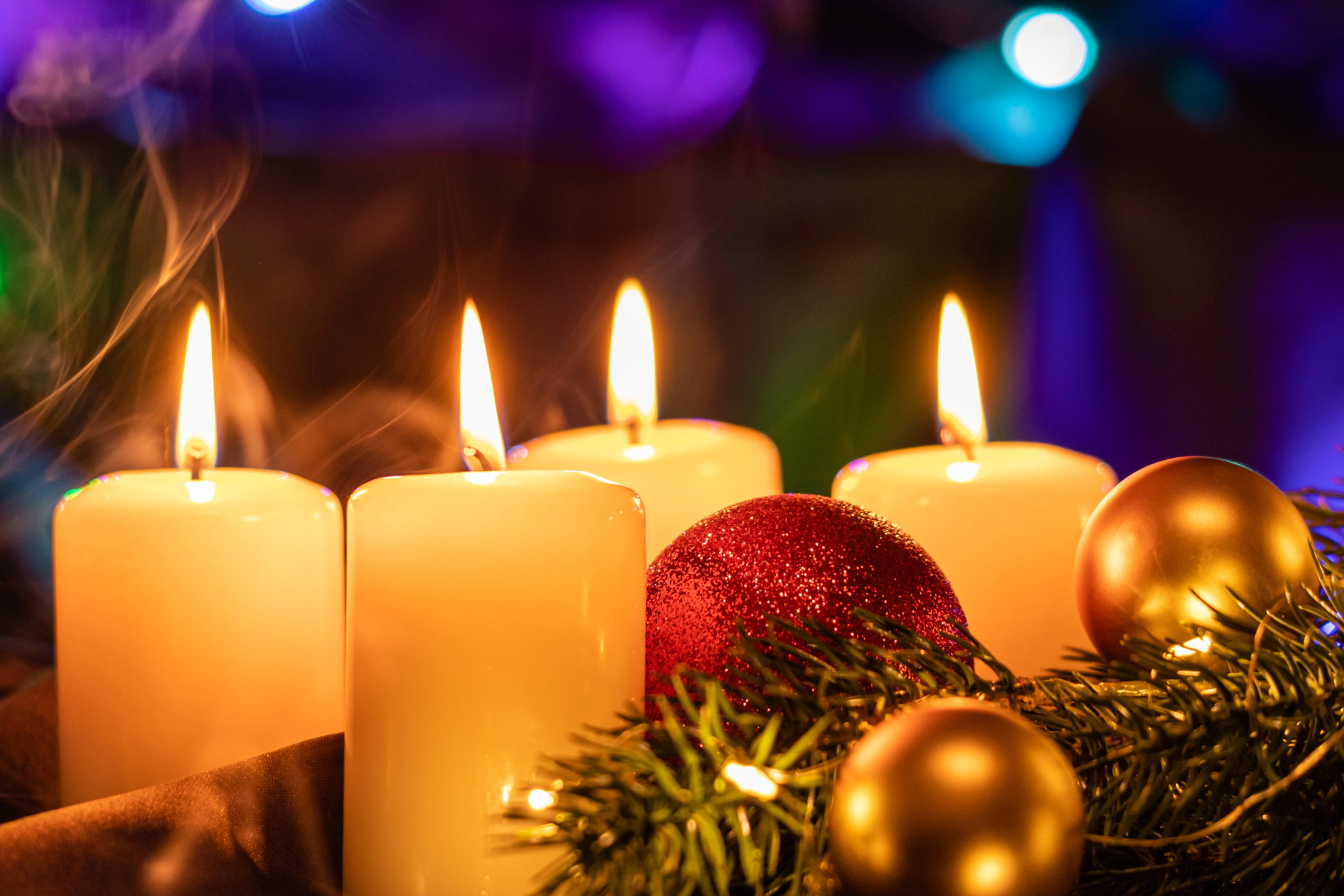 Bougies parfumées allumée sur un décors de Noël, boules et sapin.