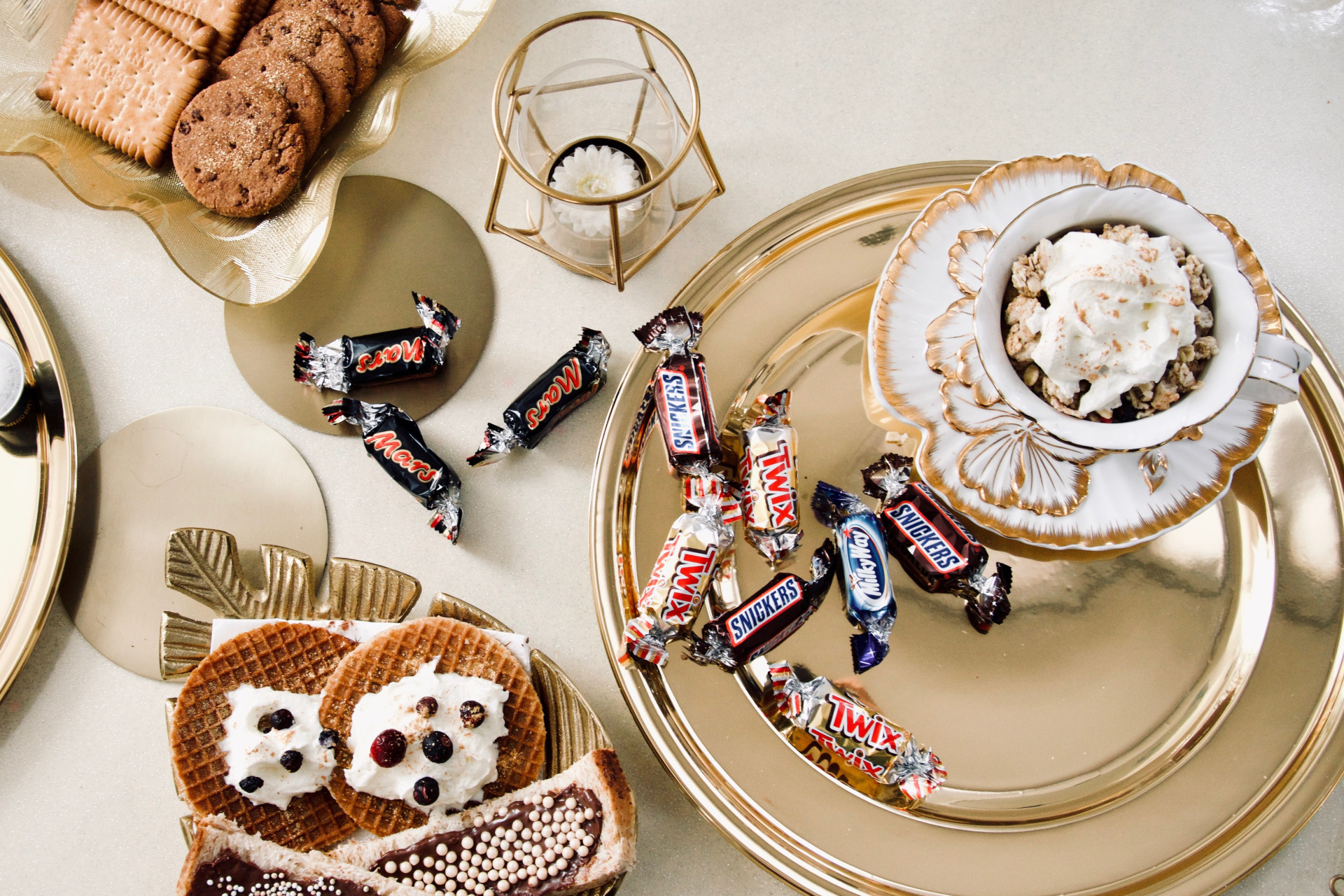 table remplie de gourmandises sucrées, bonbons, chocolats et biscuits.