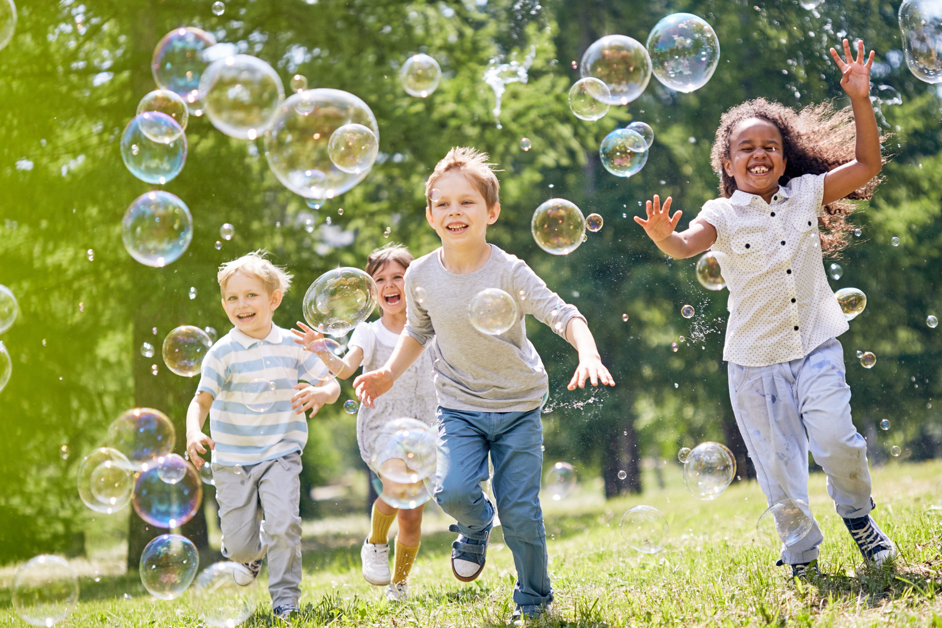 Enfants qui jouent avec des bulles dans le jardin