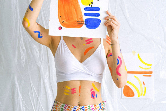 Femme qui crée des toiles en peinture sur son parquet
