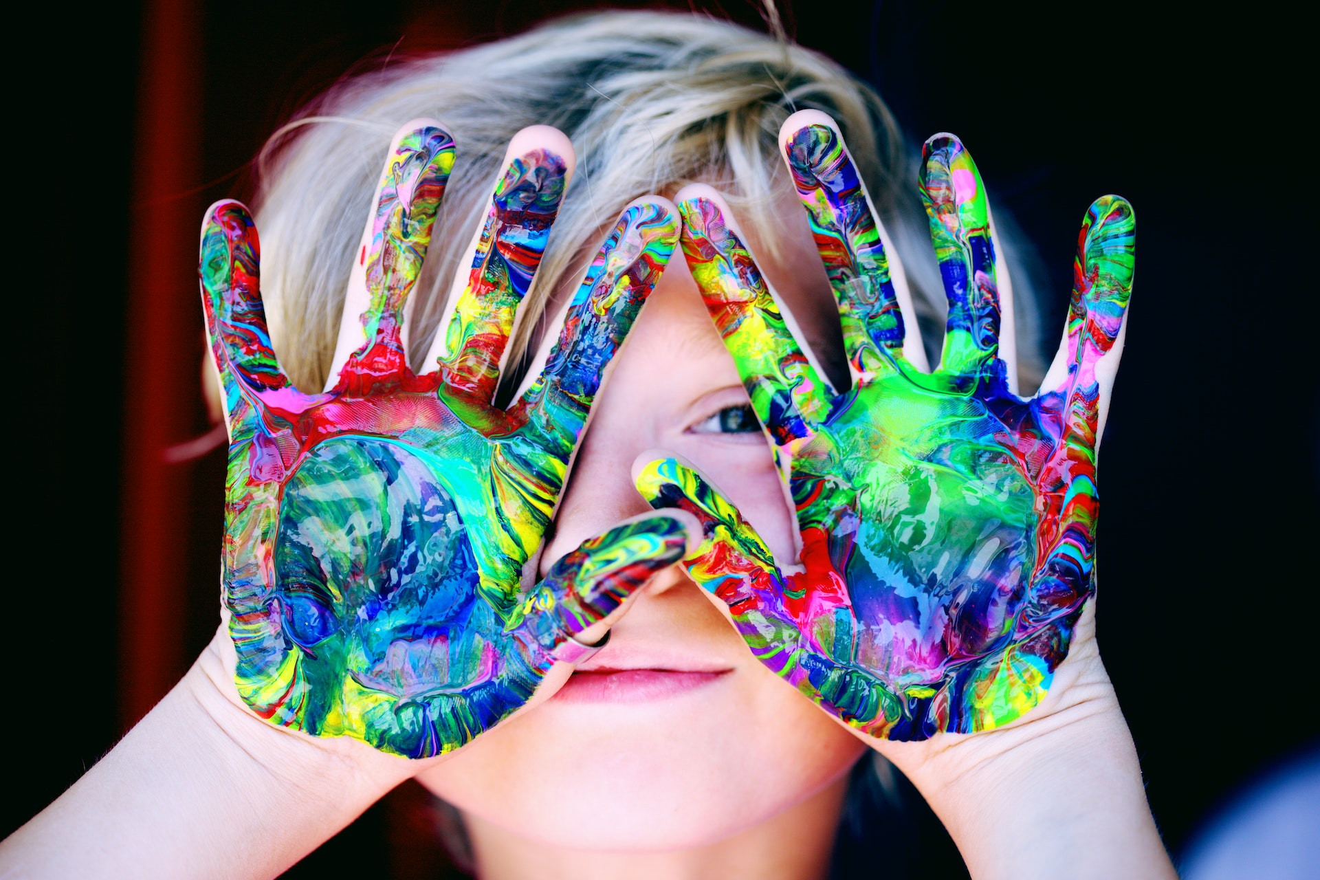 Un enfant avec les mains pleines de peinture