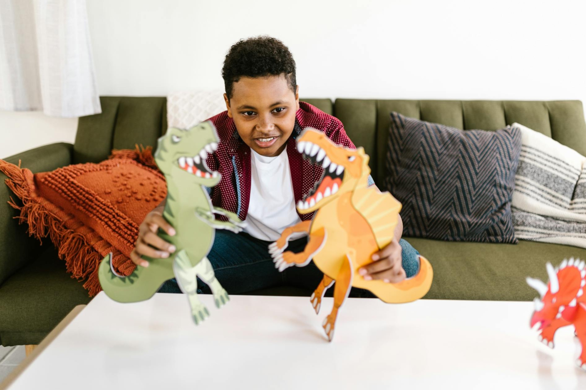 Enfants qui joue avec des dinosaures fabriqués en carton