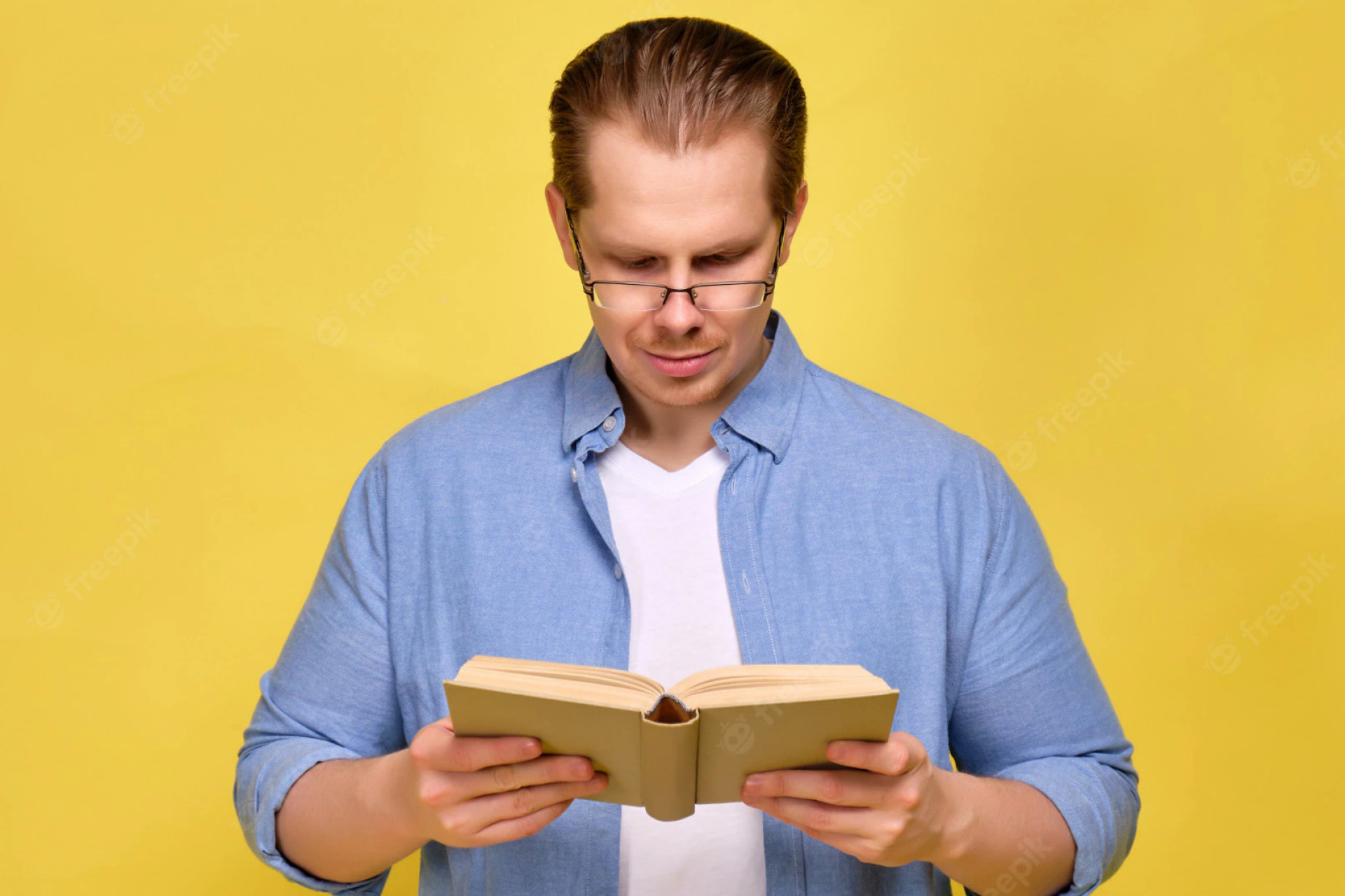 Un homme qui lit un livre sur un fond jaune